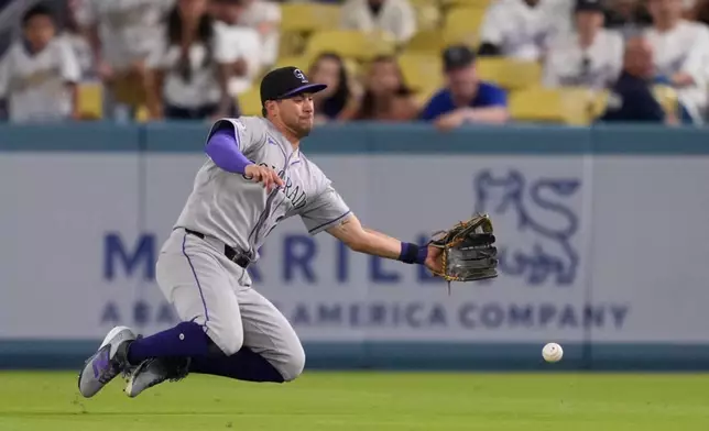Colorado Rockies right fielder Troy Johnston can't handle a ball hit for a single by Los Angeles Dodgers' Tommy Edman during the eighth inning of a baseball game Wednesday, July 8, 2026, in Los Angeles. (AP Photo/Mark J. Terrill)