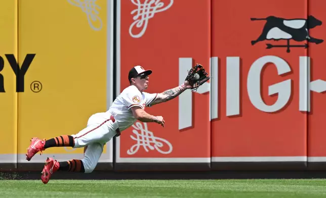 Baltimore Orioles right fielder Tyler O'Neill (9) makes a diving catch against the Chicago White Sox in the fourth inning of a MLB baseball game on Wednesday, July 1, 2026 in Baltimore, Md. (AP Photo/Gail Burton)