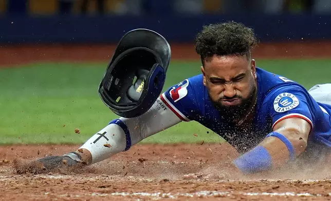 Texas Rangers' Ezequiel Duran loses his helmet after scoring on an RBI single by Evan Carter off Tampa Bay Rays pitcher Craig Kimbrel during the eighth inning of a baseball game Tuesday, July 28, 2026, in St. Petersburg, Fla. (AP Photo/Chris O'Meara)