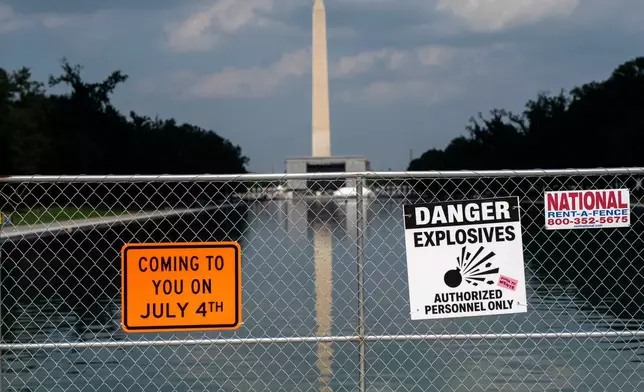 Signage and security fencing warns of explosives along the Lincoln Memorial Reflecting Pool ahead of July 4th events on the National Mall, Wednesday, July 1, 2026, in Washington. (AP Photo/Nathan Howard)