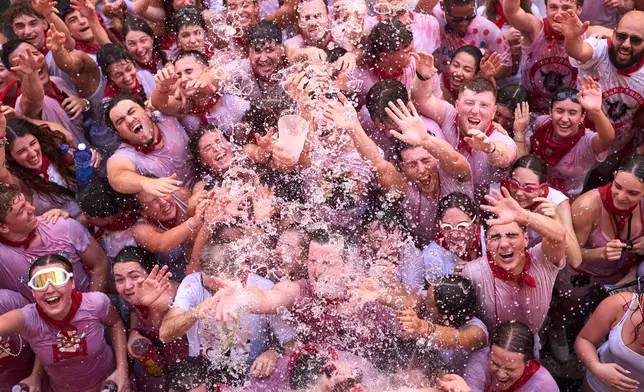 Revelers celebrate as the txupinazo, the traditional rocket marking the start of the San Fermín festival, kicks off nine days of uninterrupted festivities in Pamplona, Spain, Monday, July 6, 2026. (AP Photo/Miguel Oses)