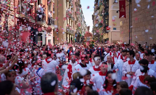 Revelers attend a procession during the San Fermín festival in Pamplona, northern Spain, Tuesday, July 7, 2026. (AP Photo/Miguel Oses)
