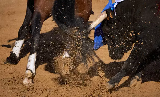 A bull charges at the horse of Spanish rejoneador Andy Cartagena during a bullfight at the San Fermín festival in Pamplona, northern Spain, Monday, July 6, 2026. (AP Photo/Miguel Oses)