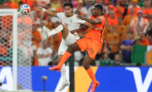 Morocco's Anass Salah Eddine (26) and Netherlands' Denzel Dumfries (22) jump for control of the ball during the World Cup round of 32 soccer match between the Netherlands and Morocco in Guadalupe, near Monterrey, Mexico, Monday, June 29, 2026. (AP Photo/Addison Simmons)
