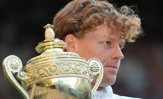 Jannik Sinner of Italy holds up the winners trophy after defeating Alexander Zverev of Germany in the men's singles final at Wimbledon Tennis Championships in London, Sunday, July 12, 2026. (AP Photo/Kin Cheung)