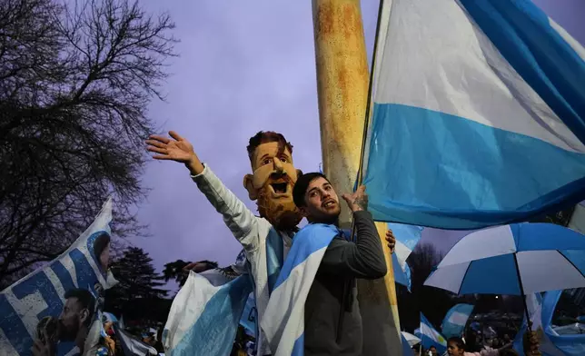 An Argentina fan wearing a mask depicting Lionel Messi gathers outside the Argentine Football Association headquarters while waiting for the national team to arrive in Ezeiza, on the outskirts of Buenos Aires, Monday, July 20, 2026, following its World Cup final loss to Spain. (AP Photo/Rodrigo Abd)