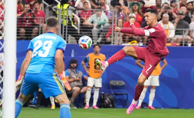 Portugal's Cristiano Ronaldo (7) shoots against Spain goalkeeper Unai Simon (23) during the World Cup round of 16 soccer match in Arlington, Texas, near Dallas, Monday, July 6, 2026. (AP Photo/Ashley Landis)