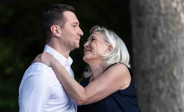 Far-right party National Rally president Jordan Bardella is embraced by far-right leader Marine Le Pen at a rally in Lievin, northern France, Saturday, July 4, 2026. (AP Photo/Jean-Francois Badias)