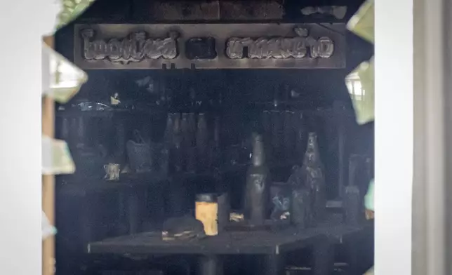 Bottles are seen sitting atop burned tables inside the music bar where a fire killed a number of people in Bangkok, Thailand, Tuesday, July 14, 2026. (AP Photo/Wason Wanichakorn)