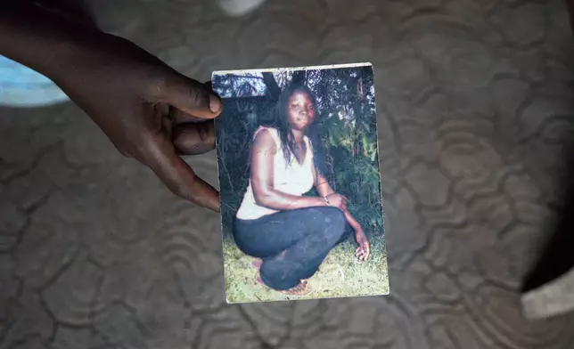 The son of Mary Olouch, who died at 25 after a botched abortion procedure, holds a photo of her in her home in Karabok, Kenya, July 20, 2025. (AP Photo/Annie Risemberg)