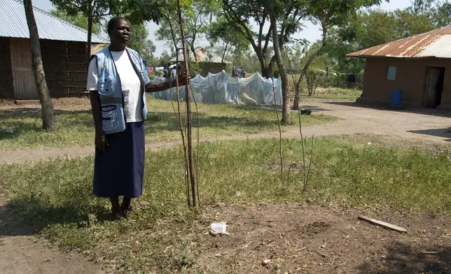 Community health worker Loice Ochieng stands over the grave of Mary Olouch, who died at 25 after a botched abortion procedure done without the help of healthcare professionals, in Karabok, Kenya, July 20, 2025. (AP Photo/Annie Risemberg)