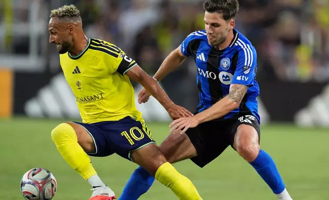 Nashville SC midfielder Hany Mukhtar (10) moves the ball past CF Montréal defender Luca Petrasso (13) during the first half of an MLS soccer match Wednesday, July 22, 2026, in Nashville, Tenn. (AP Photo/George Walker IV)
