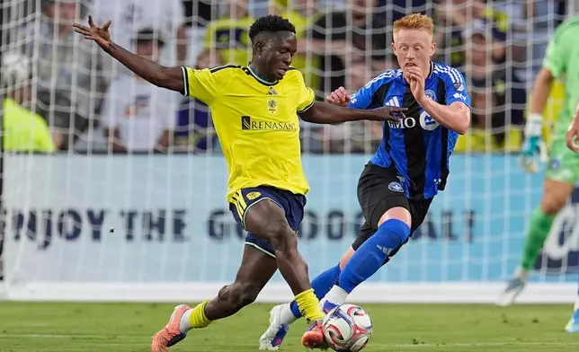 Nashville SC midfielder Shakur Mohammed, left, moves the ball past CF Montréal midfielder Matthew Longstaff, right, during the first half of an MLS soccer match Wednesday, July 22, 2026, in Nashville, Tenn. (AP Photo/George Walker IV)