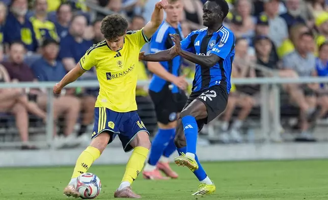 Nashville SC midfielder Matthew Corcoran, left, kicks the ball past CF Montréal midfielder Victor Loturi, right, during the first half of an MLS soccer match Wednesday, July 22, 2026, in Nashville, Tenn. (AP Photo/George Walker IV)