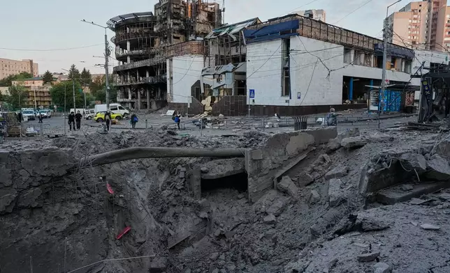 Debris surrounds a missile crater in the foreground of a building following Russia's missile attack in Kyiv, Ukraine, Sunday, July 19, 2026. (AP Photo/Efrem Lukatsky)