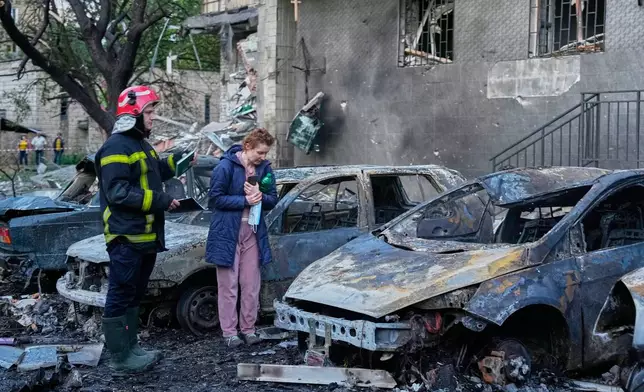An owner looks at her damaged car following a Russia missile attack in Kyiv, Ukraine, Sunday, July 19, 2026. (AP Photo/Efrem Lukatsky)