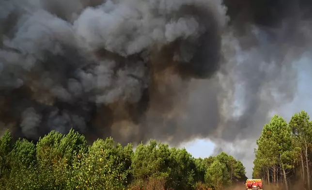 A smoke cloud rises as firefighters work to extinguish a fire in the forest near Blagon, during wildfires in southwestern France, Wednesday, July 29, 2026. (AP Photo/Emma Da Silva)