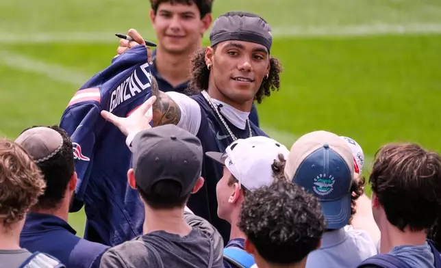 New England Patriots cornerback Christian Gonzalez signs autographs during the team's NFL football training camp, Tuesday, July 28, 2026, in Foxborough, Mass. (AP Photo/Charles Krupa)