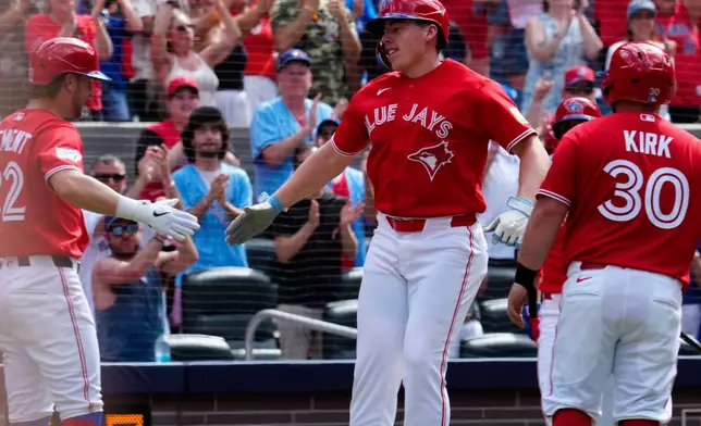 Toronto Blue Jays' Ernie Clement, left, and Alejandro Kirk congratulates Sean Keys after he hit a three run home run against the New York Mets during third inning MLB baseball action in Toronto on Wednesday, July 1, 2026. (Frank Gunn/The Canadian Press via AP)