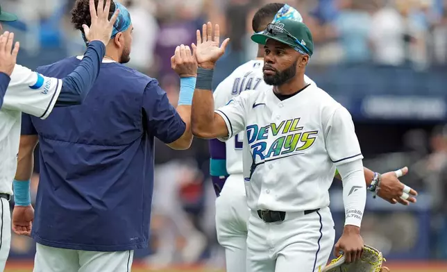 Tampa Bay Rays center fielder Cedric Mullins, right, celebrates with teammates after defeating the Cleveland Guardians during a baseball game Sunday, July 26, 2026, in St. Petersburg, Fla. (AP Photo/Chris O'Meara)