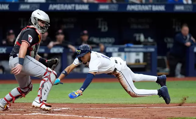 Tampa Bay Rays' Chandler Simpson, right, scores ahead of the throw to Cleveland Guardians catcher Austin Hedges on a squeeze bunt by Cedric Mullins during the fifth inning of a baseball game Sunday, July 26, 2026, in St. Petersburg, Fla. (AP Photo/Chris O'Meara)