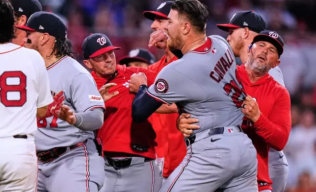 Washington Nationals' Cade Cavalli, front right, is held back as tempers flare during the fourth inning of a baseball game against the Boston Red Sox, Tuesday, June 30, 2026, in Boston. (AP Photo/Charles Krupa)