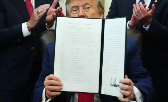 President Donald Trump holds an executive order modifying the Bears Ears National Monument in the Oval Office of the White House, Monday, July 13, 2026, in Washington. (AP Photo/Julia Demaree Nikhinson)