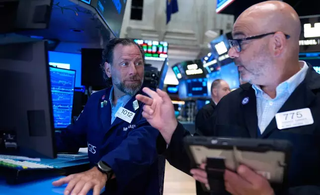 Michael Pistillo, left, and Federico DeMarco work on the floor at the New York Stock Exchange in New York, Monday, July 6, 2026. (AP Photo/Seth Wenig)