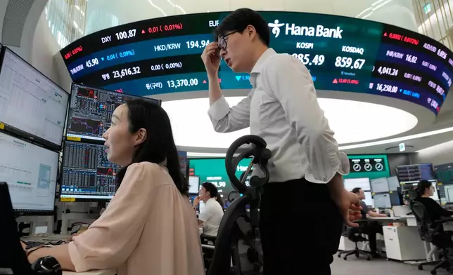 Currency traders watch monitors at the foreign exchange dealing room of the Hana Bank headquarters in Seoul, South Korea, Tuesday, July 7, 2026. (AP Photo/Ahn Young-joon)