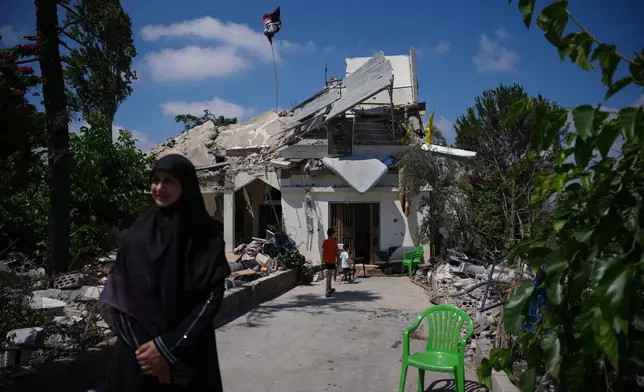 Fatima Mokdad stands outside her home, which was destroyed in an Israeli airstrike during the Israel-Hezbollah war, where she and her family continue to live, using the only room that remained intact, in Froun village, southern Lebanon, Tuesday, July 21, 2026. (AP Photo/Hassan Ammar)
