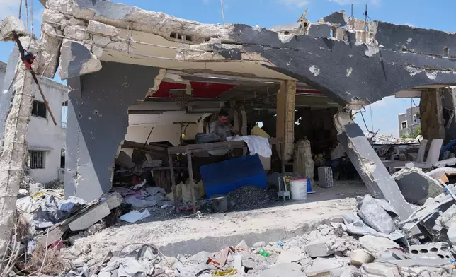 A resident works inside his shop, which was heavily damaged in an Israeli airstrike during the Israel-Hezbollah war,in Ghandouriyeh village, southern Lebanon, Tuesday, July 21, 2026. (AP Photo/Hassan Ammar)