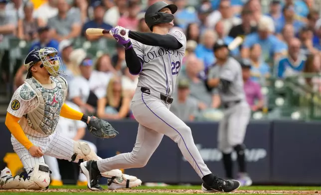 Colorado Rockies designated hitter Mickey Moniak hits a sacrifice fly, allowing Willi Castro to score, as Milwaukee Brewers catcher William Contreras, left, looks on during the fourth inning of a baseball game Friday, July 24, 2026, in Milwaukee. (AP Photo/Kayla Wolf)