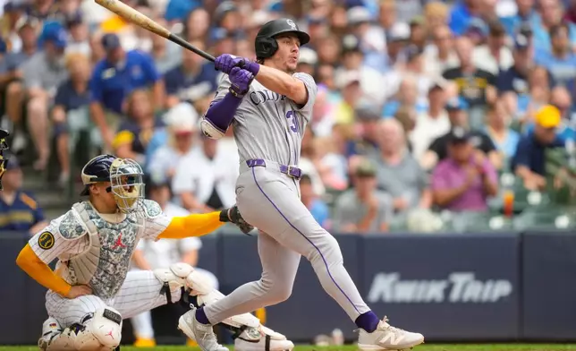 Colorado Rockies' Jake McCarthy hits a triple as Milwaukee Brewers catcher William Contreras, left, looks on during the third inning of a baseball game Friday, July 24, 2026, in Milwaukee. (AP Photo/Kayla Wolf)