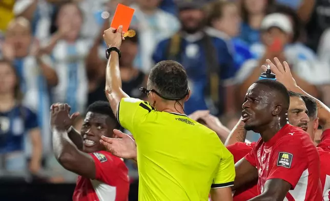 Referee Joao Pinheiro, of Portugal, gives a red card to Switzerland's Breel Embolo (7), left, during the World Cup quarterfinal soccer match between Argentina and Switzerland in Kansas City, Mo., Saturday, July 11, 2026. (AP Photo/Ed Zurga)
