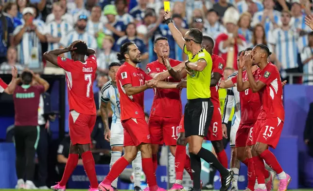 Switzerland's players argue referee Joao Pinheiro, of Portugal, gives a second yellow card to Breel Embolo (7) during the World Cup quarterfinal soccer match between Argentina and Switzerland in Kansas City, Mo., Saturday, July 11, 2026. (AP Photo/Ed Zurga)