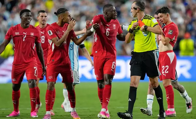 Swiss players remonstrate with referee Joao Pinheiro, of Portugal after teammate Breel Embolo (7) was given a red card during the World Cup quarterfinal soccer match between Argentina and Switzerland in Kansas City, Mo., Saturday, July 11, 2026. (AP Photo/Ashley Landis)