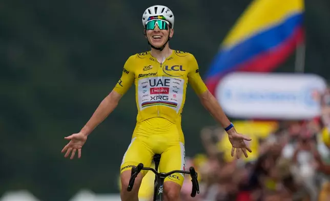 Slovenia's Tadej Pogacar, wearing the overall leader's yellow jersey, celebrates as he crosses the finish line to win the fourteenth stage of the Tour de France cycling race with start in Mulhouse and finish in Le Markstein Fellering, France, Saturday, July 18, 2026. (AP Photo/Mosa'ab Elshamy)