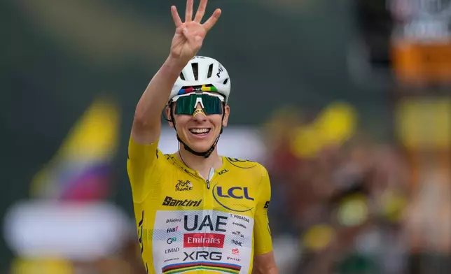 Slovenia's Tadej Pogacar, wearing the overall leader's yellow jersey, celebrates as he crosses the finish line to win the fourteenth stage of the Tour de France cycling race with start in Mulhouse and finish in Le Markstein Fellering, France, Saturday, July 18, 2026. (AP Photo/Mosa'ab Elshamy)