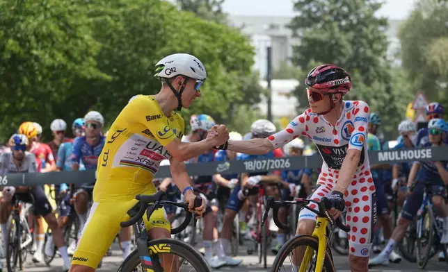 Slovenia's Tadej Pogacar, wearing the overall leader's yellow jersey, and Denmark's Jonas Vingegaard, wearing the best climber's dotted jersey, shake hands before the fourteenth stage of the Tour de France cycling race with the start in Mulhouse and the finish in Le Markstein Fellering, France, Saturday, July 18, 2026. (AP Photo/Thibault Camus)