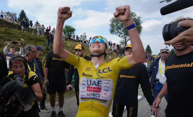 Slovenia's Tadej Pogacar, wearing the overall leader's yellow jersey, celebrates after winning the fourteenth stage of the Tour de France cycling race with start in Mulhouse and finish in Le Markstein Fellering, France, Saturday, July 18, 2026. (AP Photo/Thibault Camus, Pool)