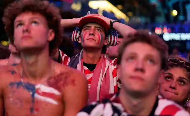 Fans react to a United States loss during a watch party for a World Cup round of 16 soccer match between the United States and Belgium at the KC Live! entertainment district Monday, July 6, 2026, in Kansas City, Mo. (AP Photo/Charlie Riedel)