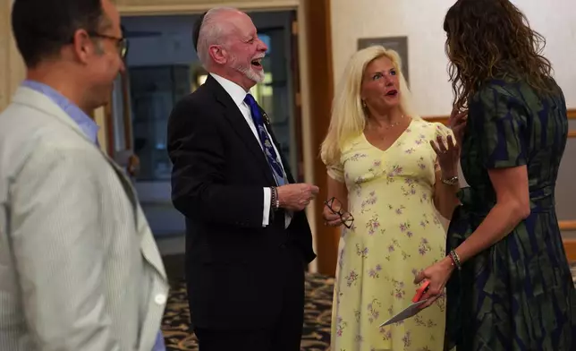Rabbi Jeffrey Myers of the Tree of Life Congregation, second from left, visits with friends, family and community members at his retirement dinner celebration on Friday, July 17, 2026, at Rodef Shalom Congregation in Pittsburgh. (AP Photo/Jessie Wardarski)
