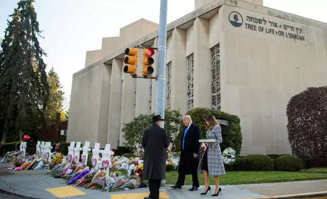 FILE - Tree of Life Rabbi Jeffrey Myers, left, walks President Donald Trump and first lady Melania Trump to a memorial outside the Tree of Life Synagogue in Pittsburgh, on Oct. 30, 2018, for those who were fatally shot days earlier. (AP Photo/Andrew Harnik, File)