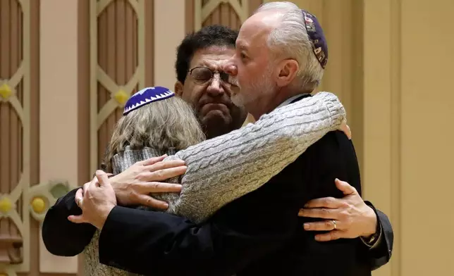 FILE - Rabbi Jeffrey Myers, right, of Tree of Life/Or L'Simcha Congregation hugs Rabbi Cheryl Klein, left, of Dor Hadash Congregation and Rabbi Jonathan Perlman during a community gathering held in the aftermath of a deadly shooting at the Tree of Life Synagogue in Pittsburgh, on Oct. 28, 2018. Perlman took shelter in a supply closet with three members of his New Light congregation during the attack. (AP Photo/Matt Rourke, File)