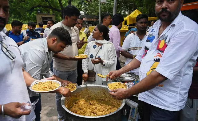 A supporter distributes food to protestors during a demonstration demanding educational reforms as part of the Cockroach Janta Party's ongoing protest movement in New Delhi, India, Thursday, July 23, 2026. (AP Photo/Vipin)