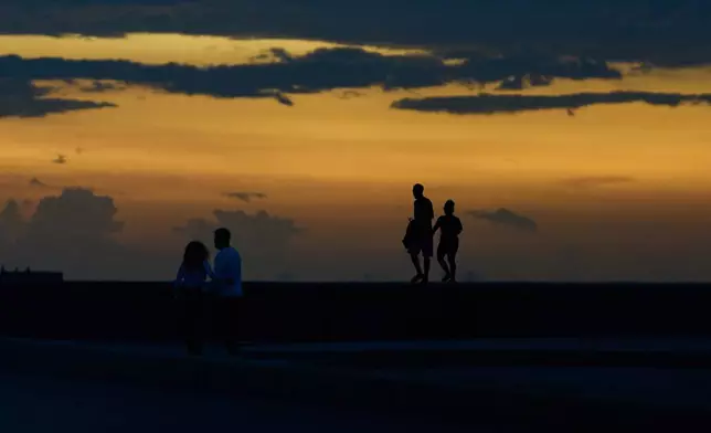 People spend time walking on the Malecón seawall during a blackout in Havana, Cuba, Friday, July 10, 2026. (AP Photo/Ramon Espinosa)