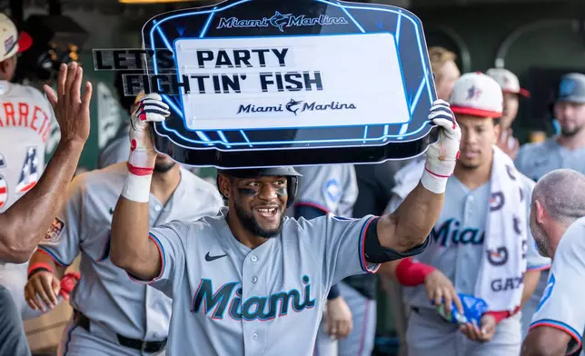 Miami Marlins' Otto Lopez, center, celebrates in the dugout after hitting a two-run home run during the third inning of a baseball game against the Athletics, Saturday, July 4, 2026, in West Sacramento, Calif. (AP Photo/Sara Nevis)