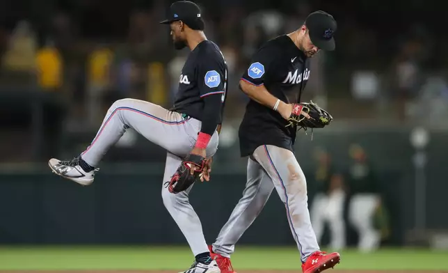 Miami Marlins' Otto Lopez, left, and Jakob Marsee, right, celebrate the Miami Marlins win over the Athletics in a baseball game Friday, July 3, 2026, in West Sacramento, Calif. (AP Photo/Scott Marshall)
