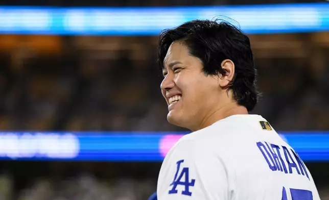 Los Angeles Dodgers' Shohei Ohtani smiles during the eleventh inning of a baseball game against the Colorado Rockies in Los Angeles, Monday, July 6, 2026. (AP Photo/Kyusung Gong)