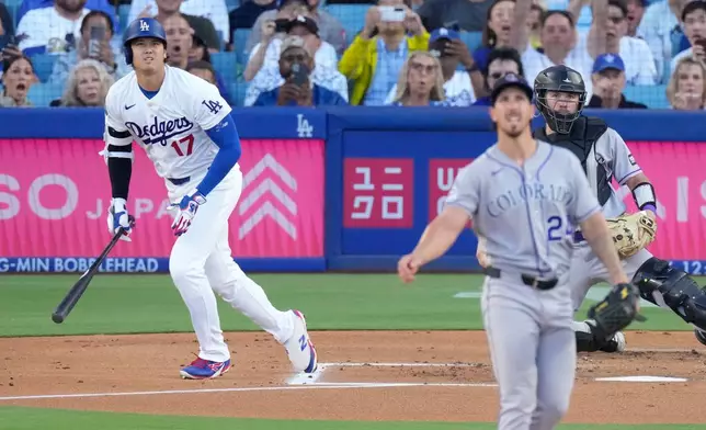 Los Angeles Dodgers' Shohei Ohtani, left, heads to first for a solo home run as Colorado Rockies starting pitcher Michael Lorenzen, center, and catcher Braxton Fulford watch during the first inning of a baseball game Tuesday, July 7, 2026, in Los Angeles. (AP Photo/Mark J. Terrill)